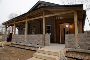 The homes have two units connected by a front porch.